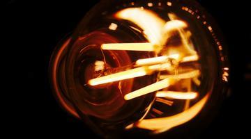 A lightbulb lit up on a dark background