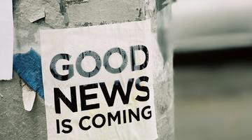 A poster on a wall saying "good news is coming"