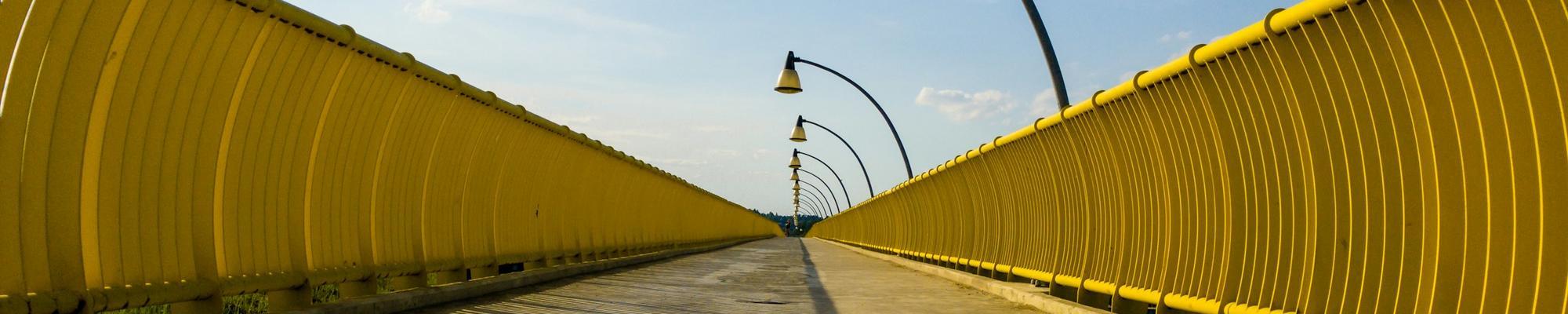 A photo of some lamp posts on a yellow bridge