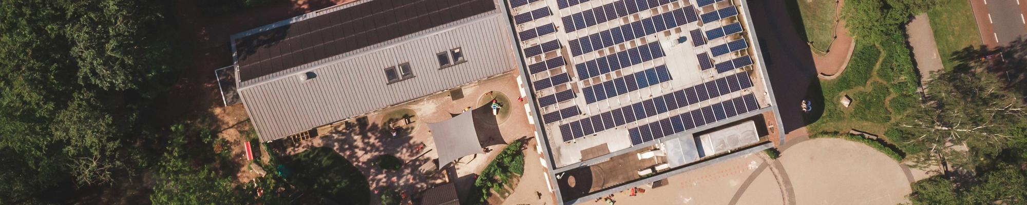 A photo of a building from above with solar panels on it